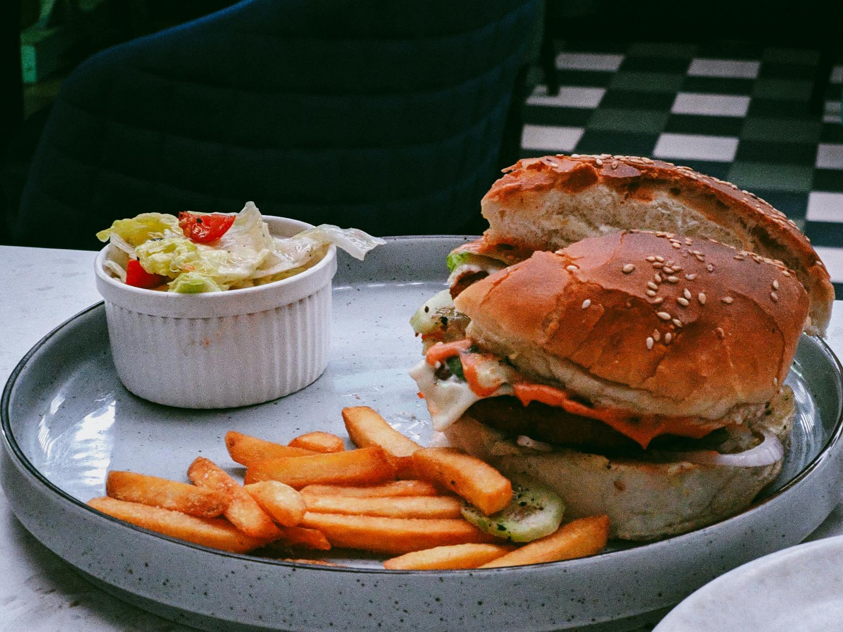 https://www.pexels.com/photo/juicy-burger-with-fries-and-salad-on-plate-29841572/